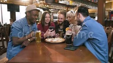 群快乐的hipster朋友一起看视频，拍照在智能手机上一起在酒吧，酒吧..